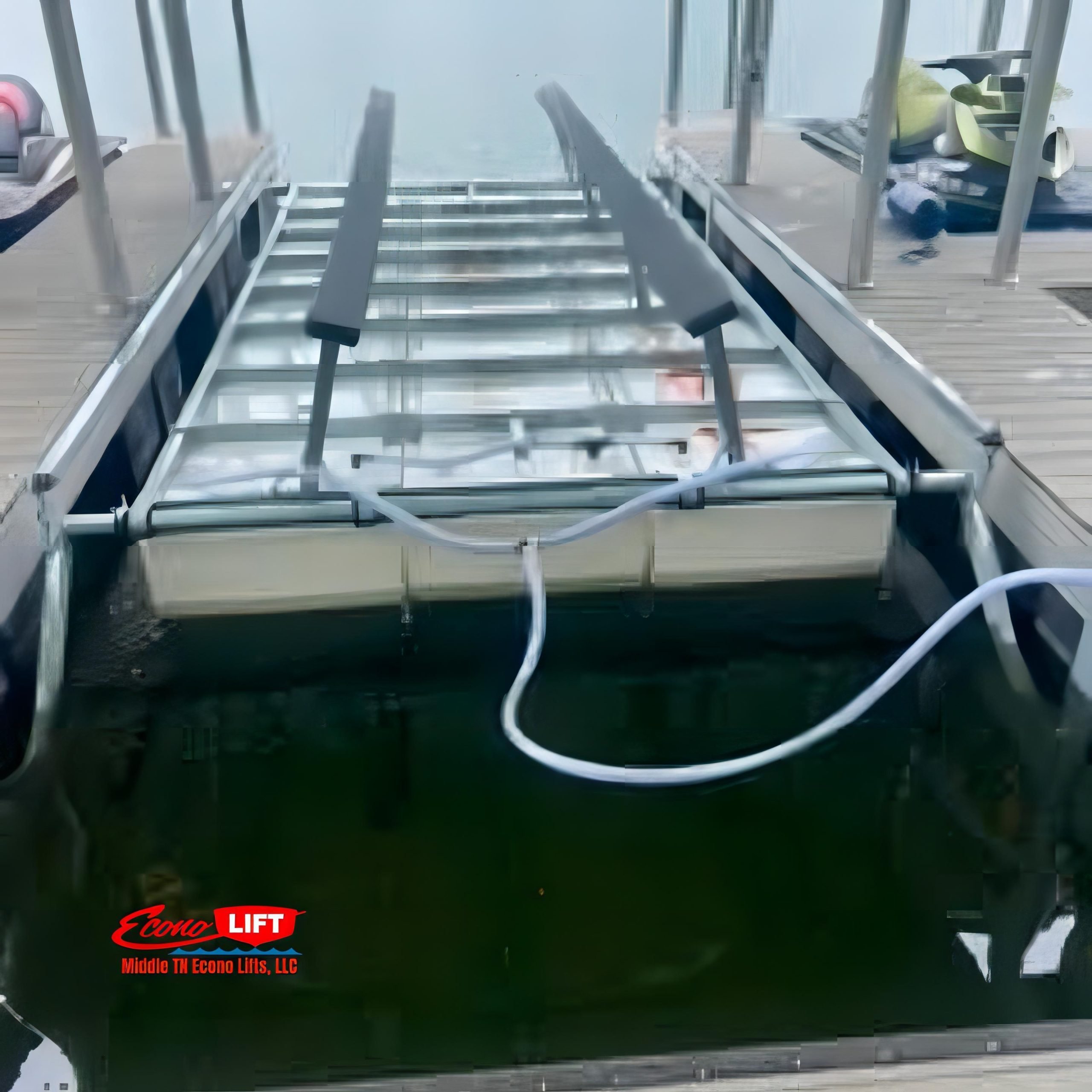 Boat cradled on a Middle TN Econo Lifts 6500lb capacity shallow water lift, with clear lake waters and a cloudy sky background.